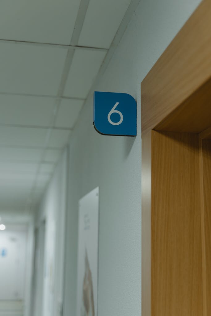 Hallway in a medical facility showcasing room number six sign.